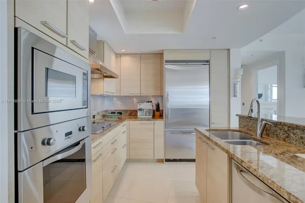 a kitchen with granite countertop cabinets stainless steel appliances and a sink
