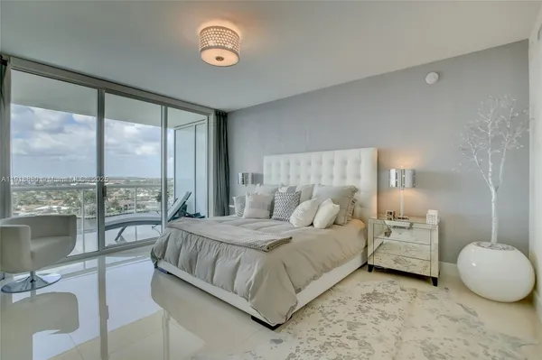 a bedroom with a bed and a large window