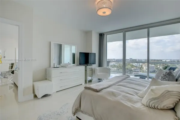 a bedroom with a bed and large windows