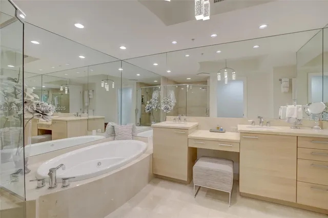 a bathroom with a tub a sink shower and mirror
