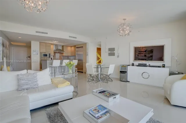 a living room with furniture a flat screen tv and kitchen view
