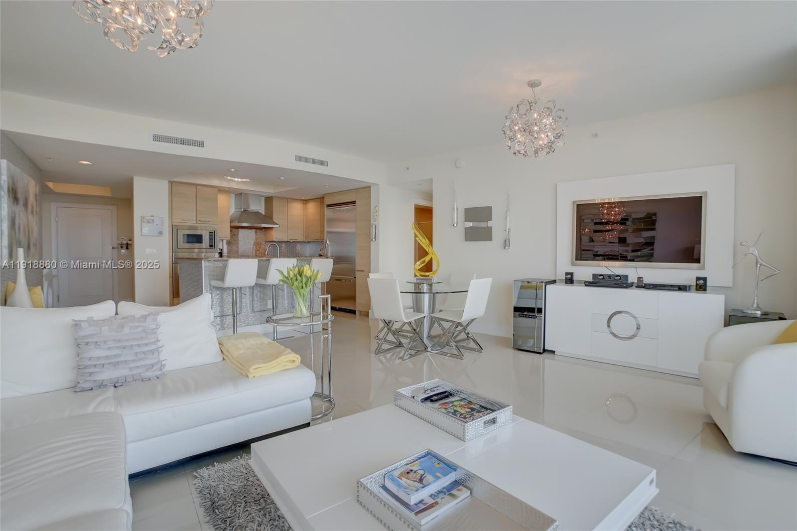 1 North Ocean Boulevard, Unit 1011 Pompano Beach, FL 33062 - Photo 8 of 48 a living room with furniture a flat screen tv and kitchen view