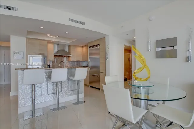 a living room with furniture a rug and kitchen view