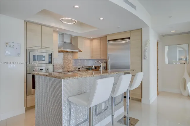 a large kitchen with kitchen island a table and chairs in it
