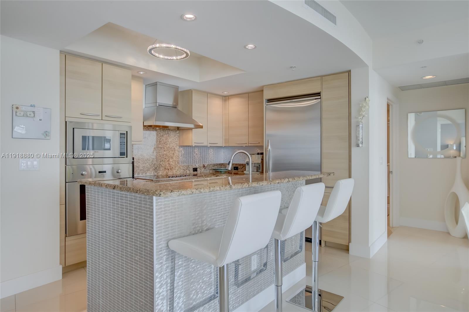 1 North Ocean Boulevard, Unit 1011 Pompano Beach, FL 33062 - Photo 10 of 48 a large kitchen with kitchen island a table and chairs in it