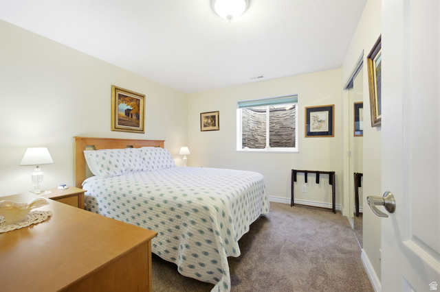 776 Flint Street Layton, UT 84041 - Photo 14 of 41 Bedroom featuring a window with a stone-lined window well, light cream walls, and a light wood-finish headboard