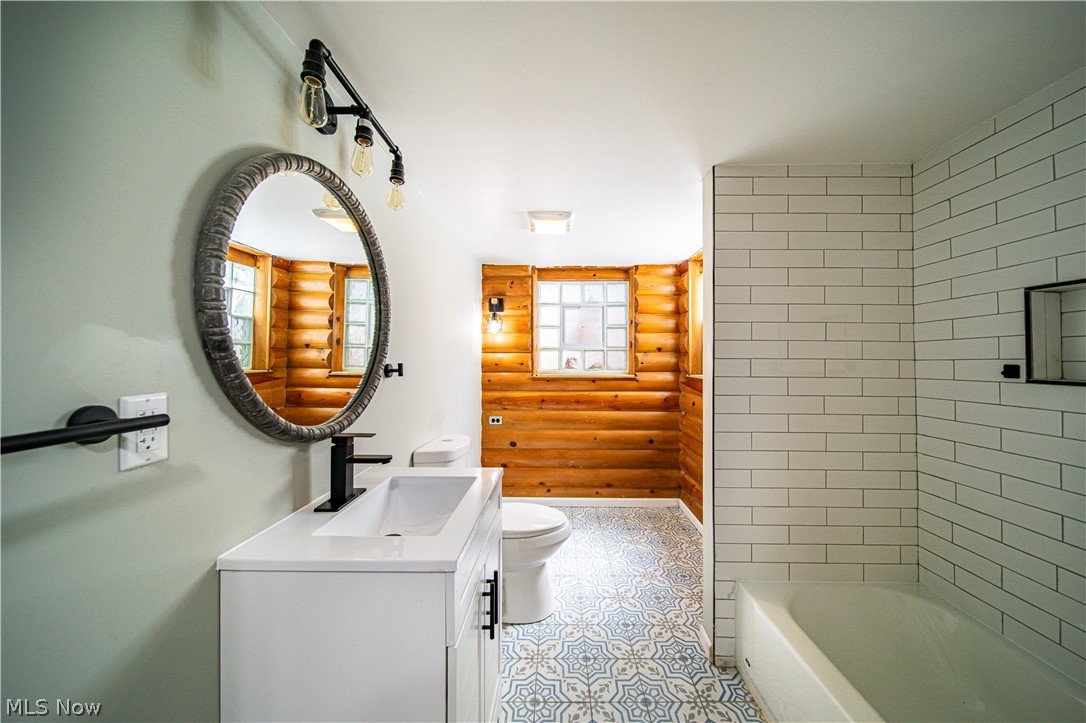 9412 Oakdale Road Parma, OH 44129 - Photo 28 of 38 Full bathroom featuring toilet, tiled shower / bath, rustic walls, tile flooring, and vanity