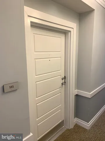 a view of a room with wooden floor and white walls