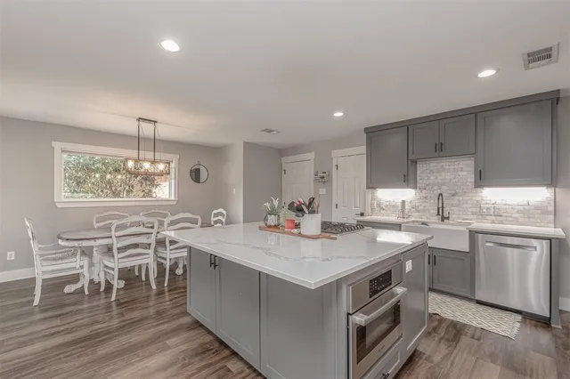 a kitchen with a sink stove and wooden cabinets