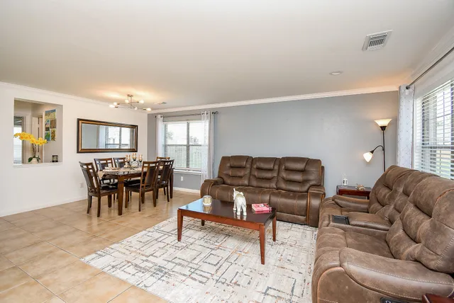 a living room with furniture a rug and kitchen view