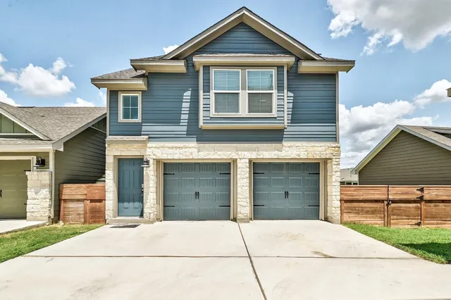 a view of the house with a garage and a yard