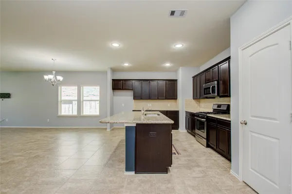 a large kitchen with stainless steel appliances granite countertop a stove and a sink