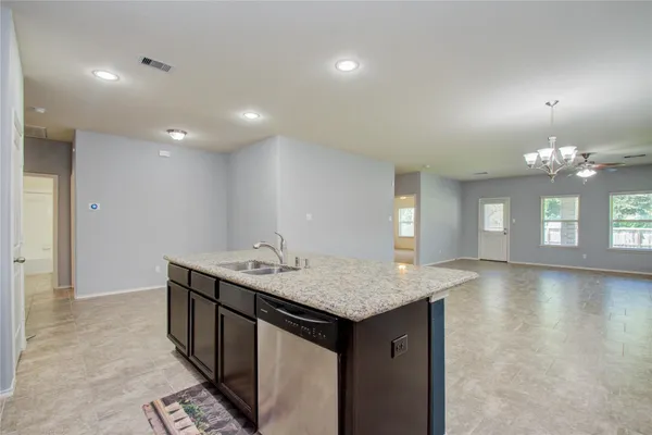 a kitchen with a sink chandelier and wooden floor