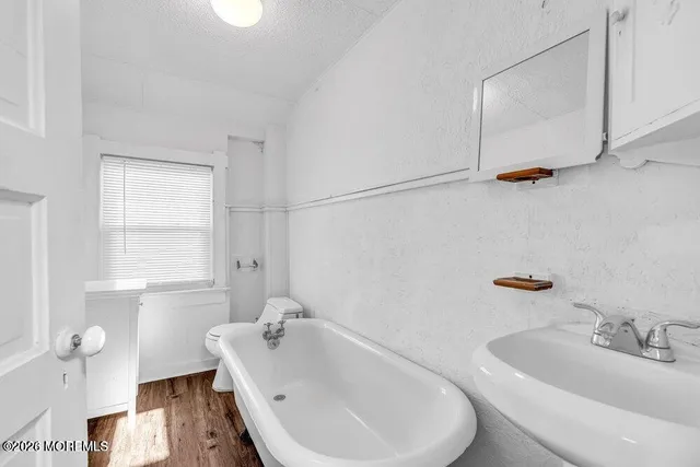a bathroom with a sink and bathtub with toilet