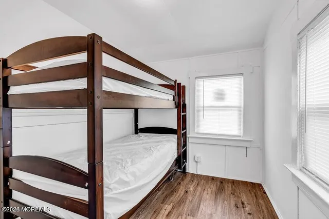 a view of bedroom with window and wooden floor