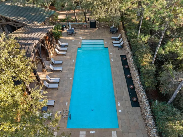 a view of swimming pool with outdoor seating and trees