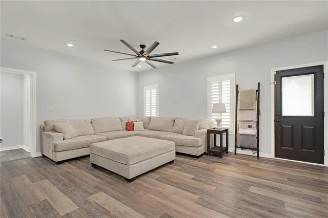 a living room with furniture and a ceiling fan