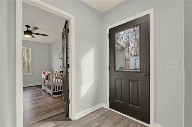 a view of a hallway with wooden floor and a bedroom