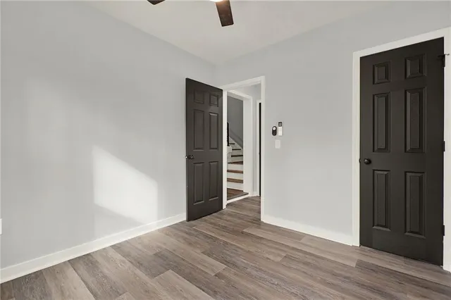 an empty room with wooden floor door and hallway