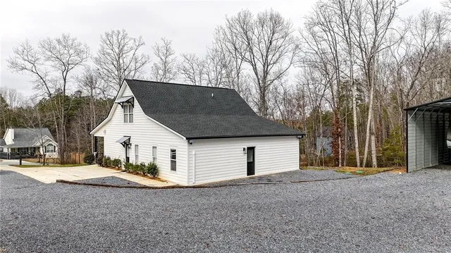 a view of a house with backyard and trees