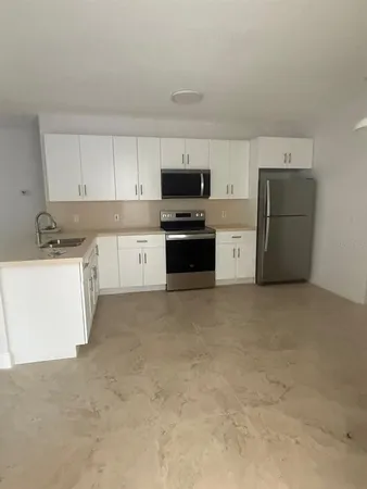 a kitchen with a refrigerator sink and stove top oven