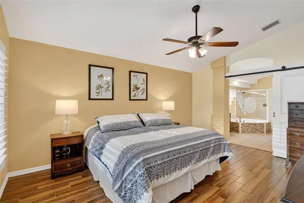 a bathroom with a granite countertop sink a mirror a bathtub and shower