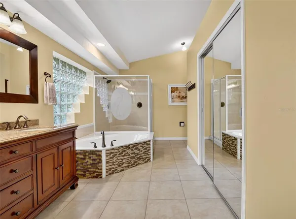 a bathroom with a granite countertop sink mirror and bathtub