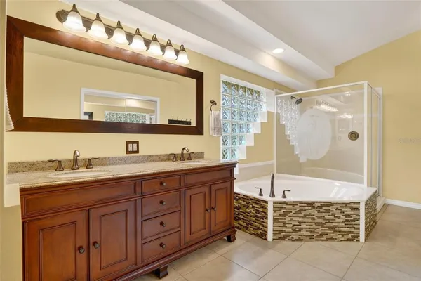 a spacious bathroom with a tub sink and mirror