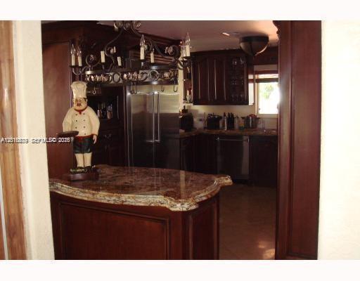 12425 Southwest 43rd Street Miami, FL 33175 - Photo 4 of 11 a kitchen view of a refrigerator and cabinets