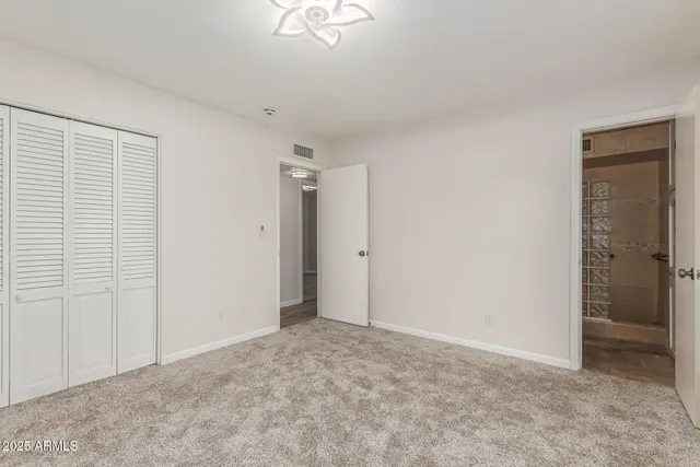 a view of an empty room with a chandelier fan