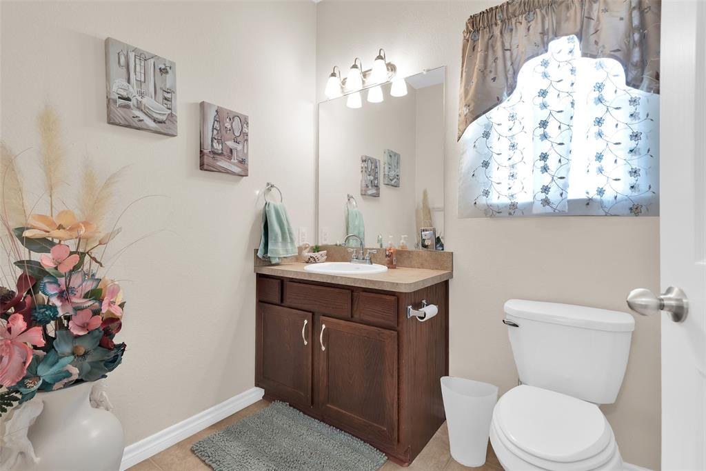 201 East Walker Street Denison, TX 75021 - Photo 14 of 19 a bathroom with a toilet a sink and mirror
