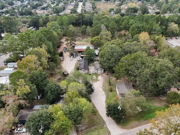 an aerial view of residential house with outdoor space and trees all around