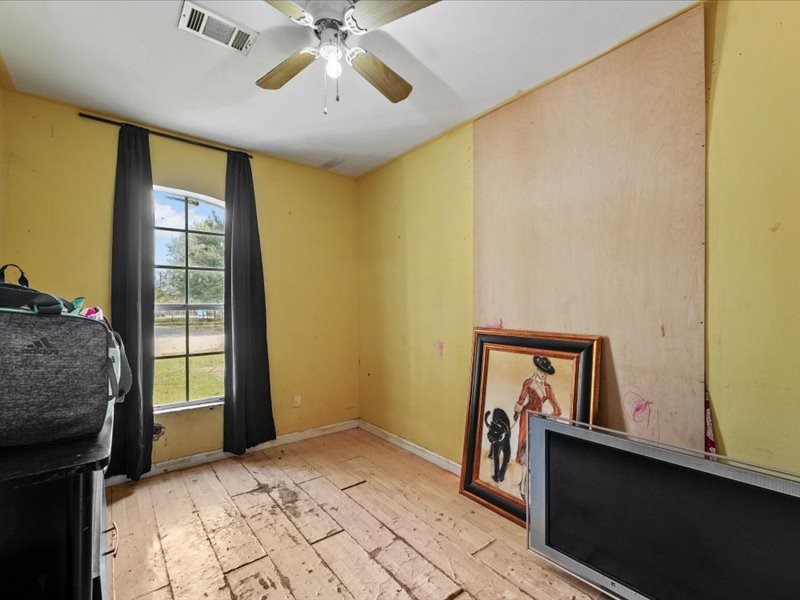 1418 South 7th Street Conroe, TX 77301 - Photo 12 of 36 a view of a bedroom with a bed and a window