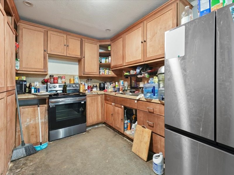 1418 South 7th Street Conroe, TX 77301 - Photo 19 of 36 a kitchen with stainless steel appliances a refrigerator sink and cabinets
