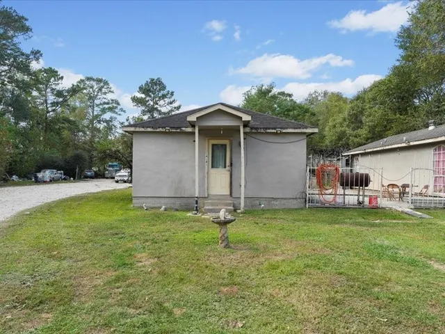 a backyard of a house with table and chairs and potted plants