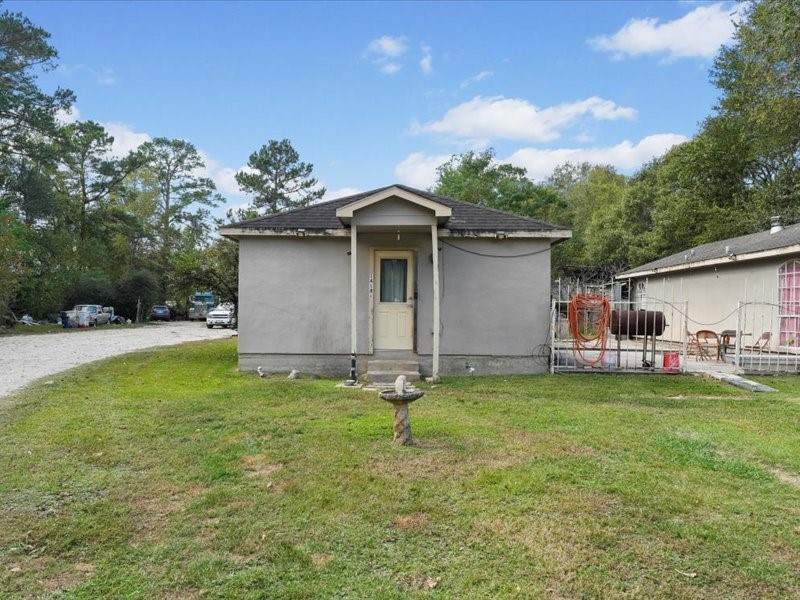 1418 South 7th Street Conroe, TX 77301 - Photo 2 of 36 a backyard of a house with table and chairs and potted plants