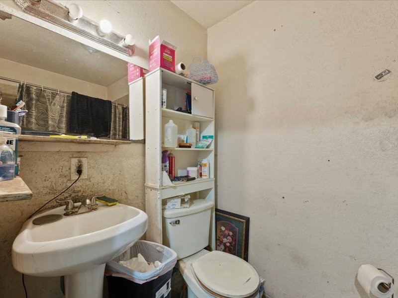 1418 South 7th Street Conroe, TX 77301 - Photo 21 of 36 a bathroom with a toilet sink and mirror