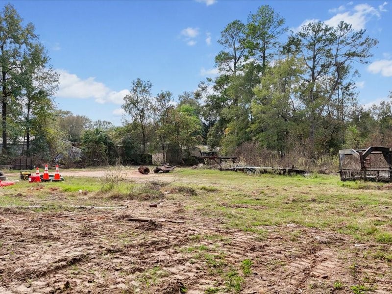 1418 South 7th Street Conroe, TX 77301 - Photo 25 of 36 a backyard of a house with a yard and outdoor seating