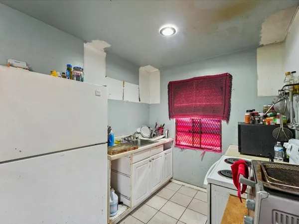 a kitchen with a refrigerator and a stove top oven