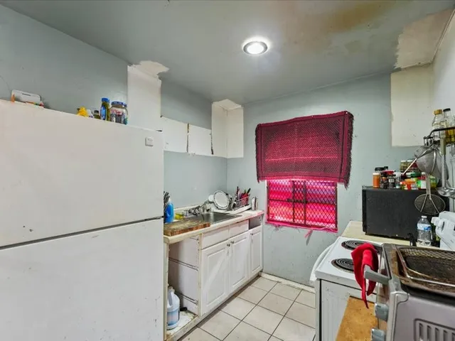 a kitchen with a refrigerator and a stove top oven
