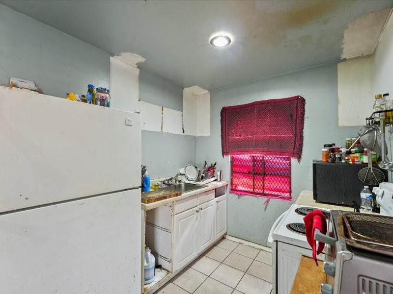 1418 South 7th Street Conroe, TX 77301 - Photo 6 of 36 a kitchen with a refrigerator and a stove top oven