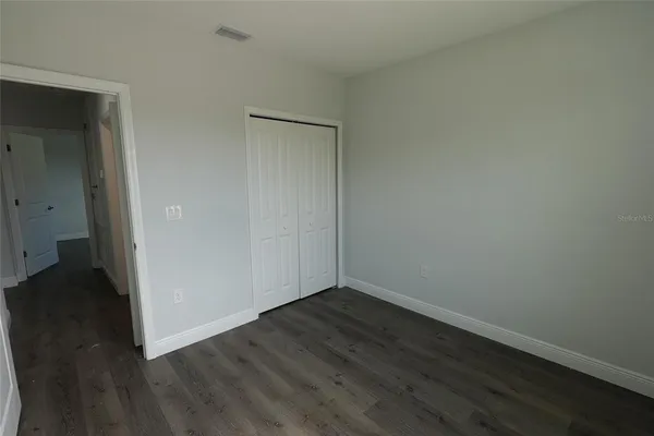 an empty room with wooden floor and a window