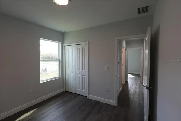 a view of an empty room with wooden floor