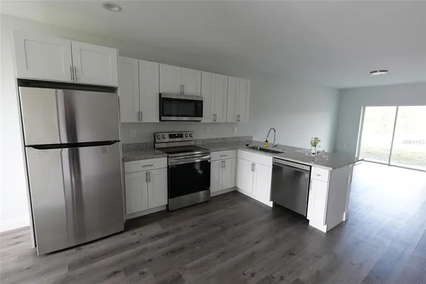 a kitchen with a refrigerator stove and wooden cabinets
