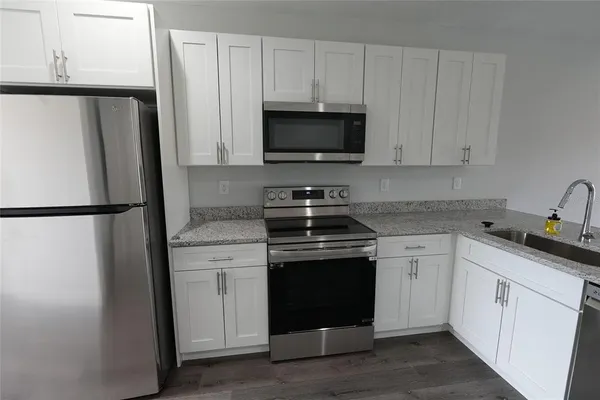 a kitchen with white cabinets and stainless steel appliances