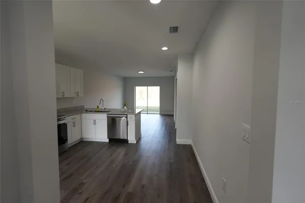 a view of a kitchen with wooden floor and a window