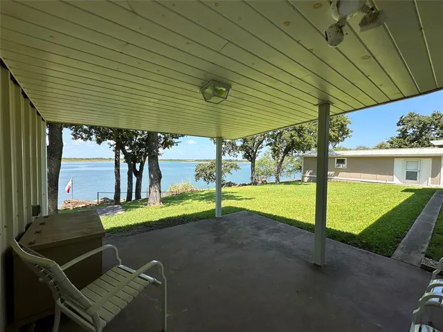 a view of a patio with table and chairs under an umbrella