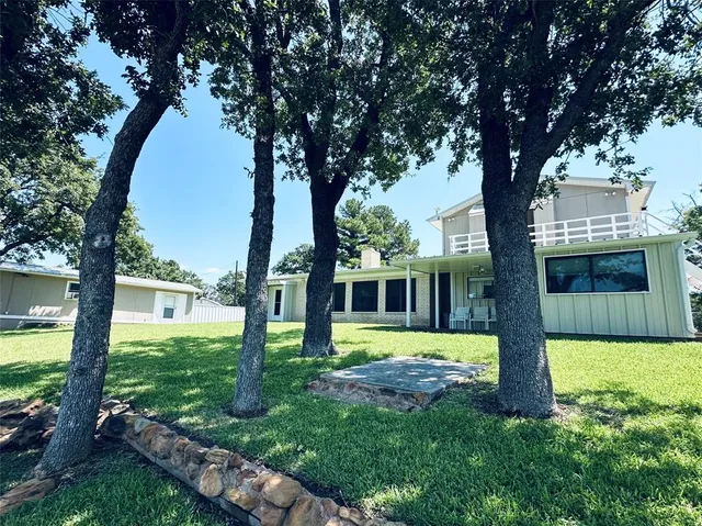 a view of a house with backyard and a tree