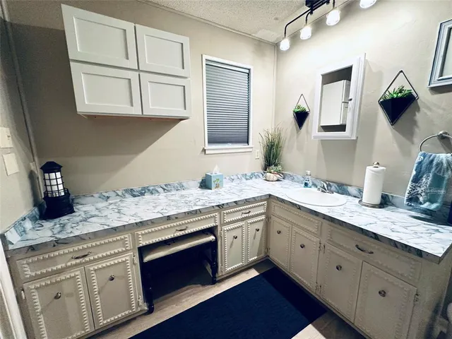 a kitchen with stainless steel appliances granite countertop a sink and cabinets with wooden floor