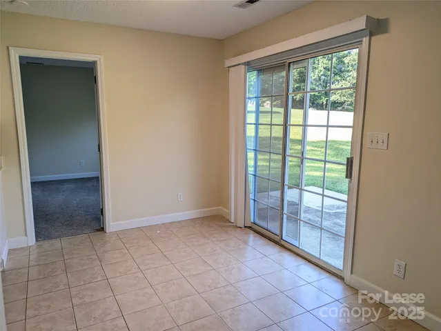 an empty room with a window and ceiling fan